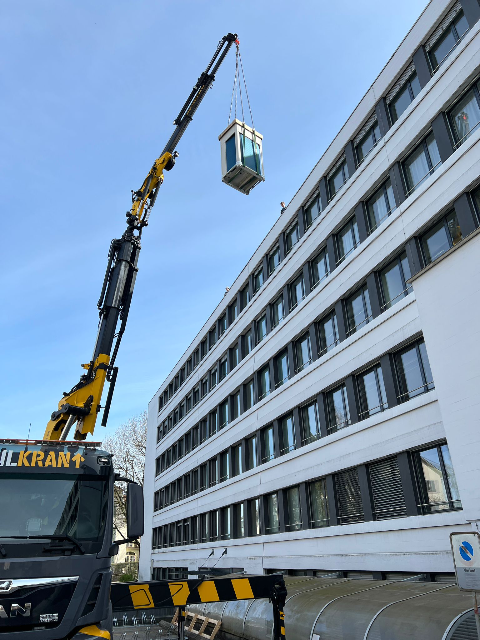 Kranmontage einer technischen Anlage an einem Grossgebäude
